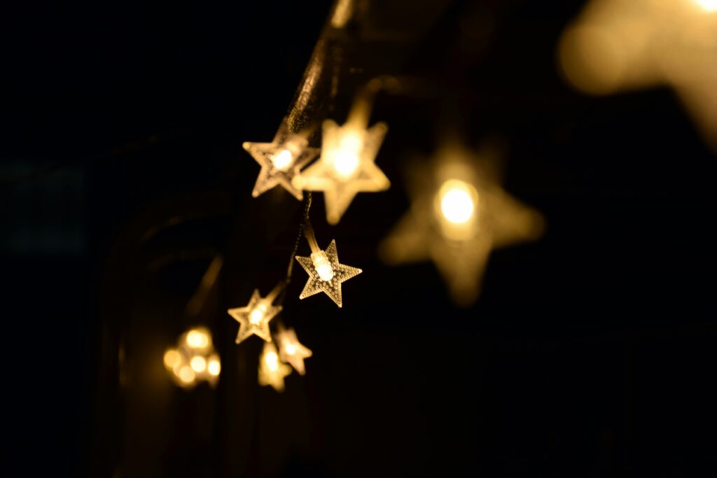 Warm star-shaped fairy lights hanging elegantly in the night, creating a festive ambiance.